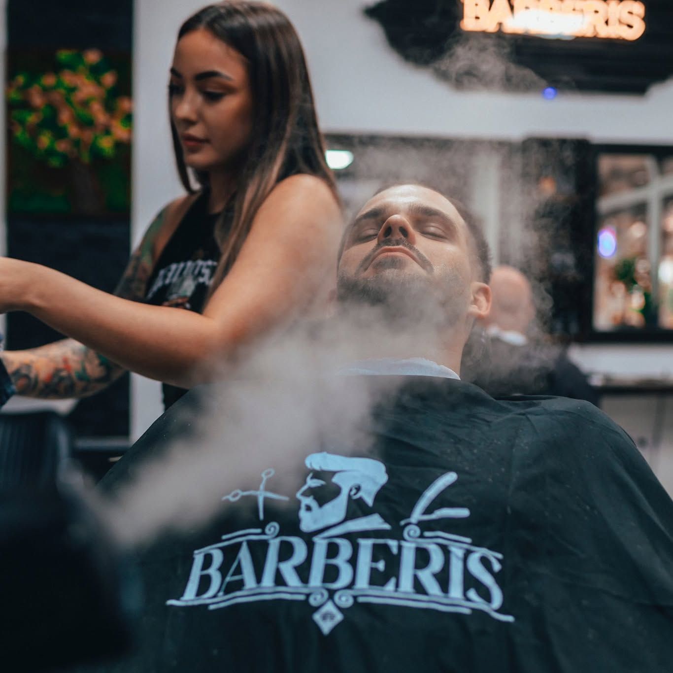 Anett pri ošetrení brady naparovaním, na zákazníkovi pláštenka BARBERIS